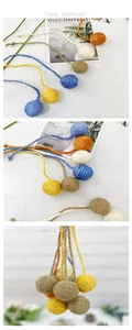 Detalle de pelotas de sisal de colores para gatos con colas largas para jugar.
