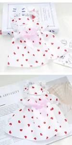 Detailed view of white pet summer dress featuring red heart prints and a decorative pink bow.
