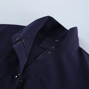 Detailopname van de kraag van een donkerblauw werkjack met metalen ritssluiting en knopen