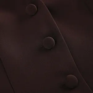 Gedetailleerde macro-opname van met stof beklede knopen op een donkerbruine elegante damesblazer
