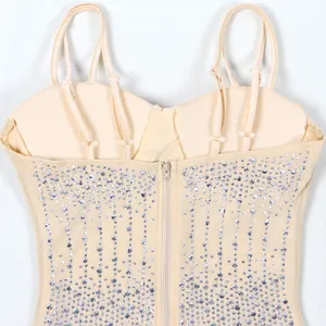 Dettaglio di un abito beige con strass e spalline sottili con cerniera sul retro e mesh.