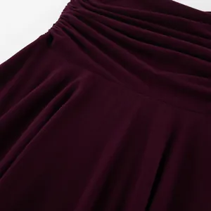 Dettaglio gonna in maglia bordeaux con sofisticata trama a pieghe drappeggiate