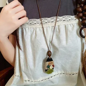 Vintage lange hanger ketting met kleurrijke knopen en groene franje kwast.