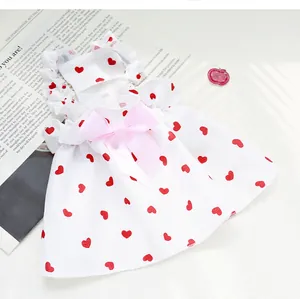 Detailed view of white pet princess dress featuring red heart prints and a pink bow