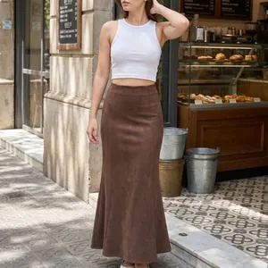 Dettaglio di donna che indossa una gonna lunga scamosciata marrone in un caffè