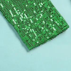Close-up macro detail of shiny bright green sequins on a sexy nightclub dress fabric
