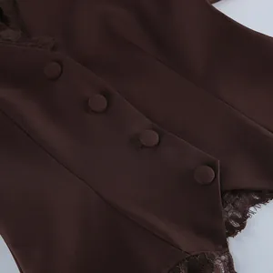 Detailopname van bruin damesvest met met stof beklede knopen en kanten afwerking