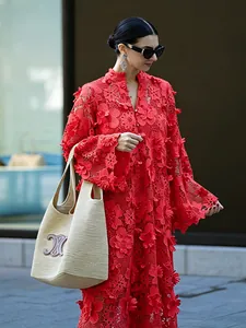 Gros plan détaillé d'une robe en dentelle florale 3D rouge vif portée par un mannequin.