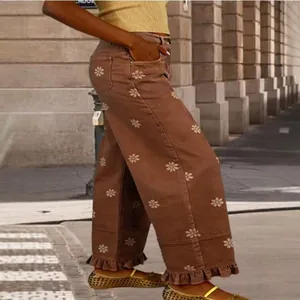 Vintage brown wide-leg denim pants featuring white floral prints and stylish ruffle hem detailing