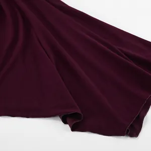 Vista ravvicinata del tessuto a maglia bordeaux con dettaglio dell'orlo drappeggiato