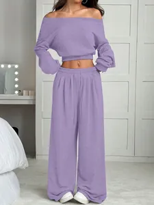 Détail de l'ensemble haut court en tricot à épaules dénudées et pantalon large violet.