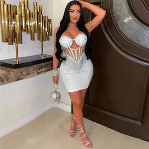 Detailed view of white bodycon mini dress featuring pearls and rhinestone fringe detailing