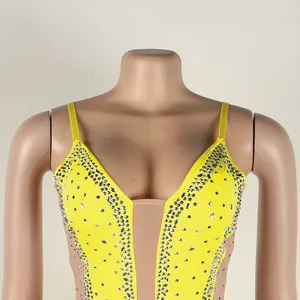 Detailed view of glamorous yellow rhinestone spaghetti strap evening dress with sheer mesh insert