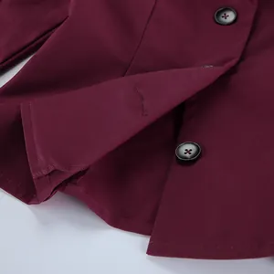 Dettaglio del blazer bordeaux slim fit che mostra i bottoni neri e l'orlo inferiore