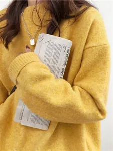 Vue détaillée d'un pull en maille jaune vif à col rond montrant la texture douce