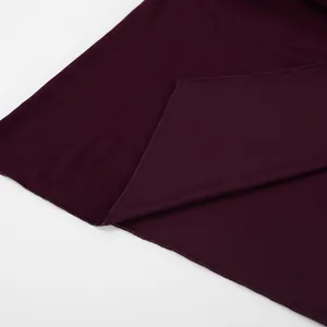 Primo piano del tessuto a maglia bordeaux con dettagli dell'orlo e morbido drappeggio.
