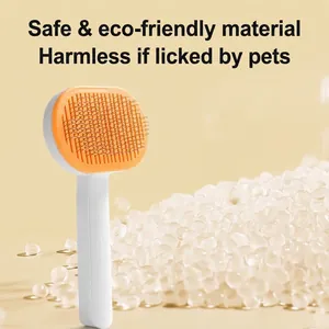 Pet grooming brush with stainless steel needles and orange oval head on beige background