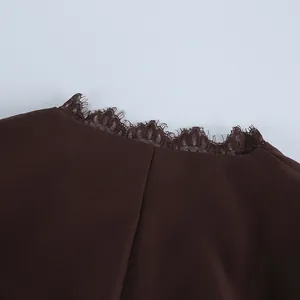 Close-up macro van de verfijnde kanten rand aan de kraag van een bruine damesblazer