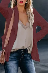 Close-up view of the sequined texture and fit of a burgundy blazer on a female model