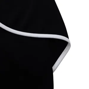 Detailed macro view showing the contrast white piping on an elegant black pencil dress fabric