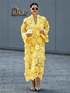 Vue détaillée de la dentelle florale 3D et de la texture évidée de la robe jaune mode