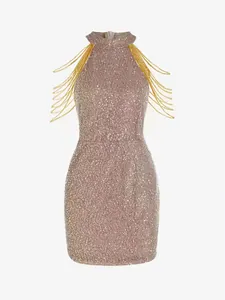 Close-up of elegant champagne sequined fabric with decorative gold chain fringe