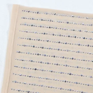 Dettaglio ravvicinato di strass argento scintillanti su tessuto mesh beige