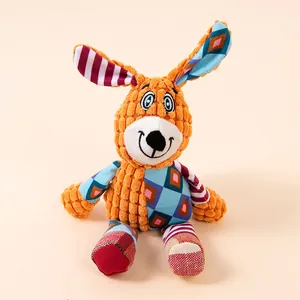 Dettaglio della trama patchwork colorata e del viso ricamato del giocattolo di peluche per cani.