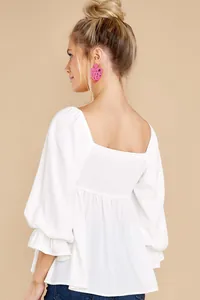 Back detail view of elegant white square neck blouse featuring smocked panel design