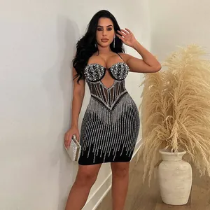 Detailed view of women's black bodycon mini dress featuring pearls and rhinestone stripes