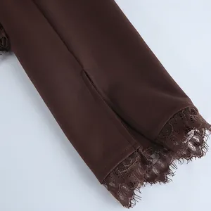 Gedetailleerde close-up van de bruine blazer mouwmanchet met kant en een zijdelingse split.
