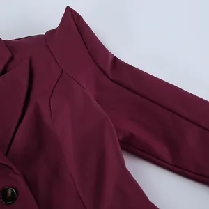 Primo piano dettagliato di un blazer bordeaux con spalline imbottite e revers molto eleganti