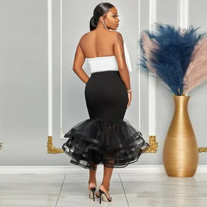 Detalle del dobladillo de sirena de malla con volantes en este conjunto de vestido blanco y negro