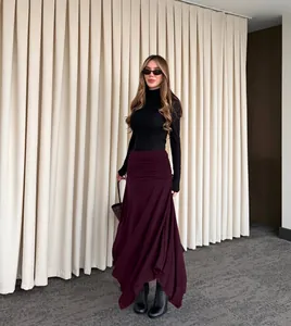 Modella indossa un'elegante gonna a trapezio in maglia bordeaux a vita alta con drappeggio