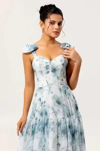Close-up detail of a blue floral organza evening dress with elegant tiered skirt.