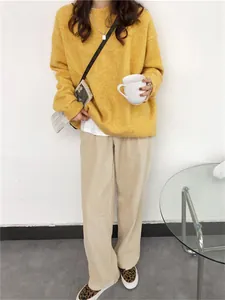 Mannequin portant un pull en maille jaune oversize avec pantalon en velours côtelé