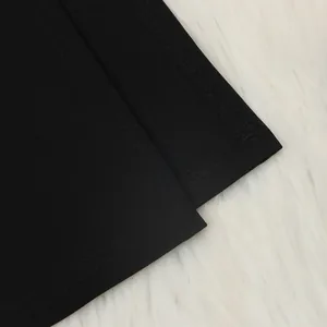 Λεπτομερής άποψη της ραφής ακριβείας και του στριφώματος σε ένα σέξι μαύρο μακρυμάνικο φόρεμα.
