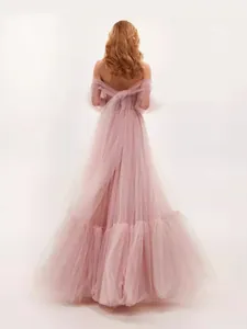 Back view of a dusty pink off-the-shoulder tulle wedding gown with full layered skirt