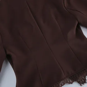 Detailopname van een bruine damesblazer met getailleerde achterkant en kanten zoom