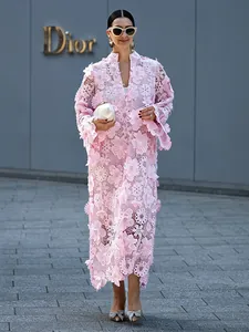 Détail d'une robe maxi rose ajourée avec appliqués floraux 3D et dentelle.