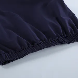 Gedetailleerde close-up van de elastische zoom van een marineblauwe katoenen werkjas.