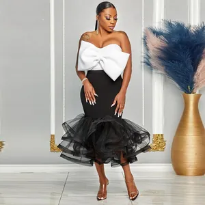 Elegante conjunto de dos piezas con top blanco sin tirantes con lazo y falda de tul negro