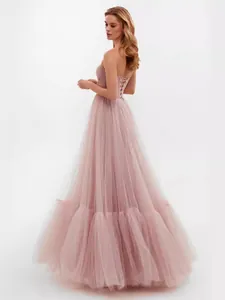 Elegant pink tulle strapless wedding gown with lace-up back and voluminous mesh skirt