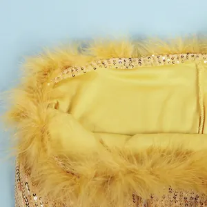 Macro view showing the detailed texture of yellow sequins and fluffy feather trim on a dress