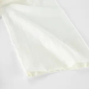 Close-up of white tencel fabric showing fine texture and clean stitching detail.