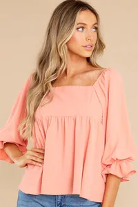 Detailed view of women's elegant coral peach square neck blouse featuring puff sleeves.