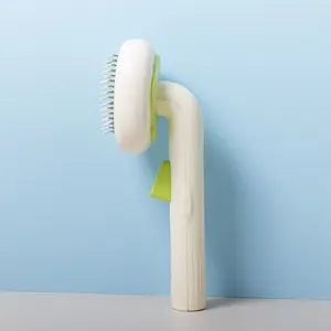 Side view detail of a self-cleaning pet grooming brush with stainless steel pins and handle