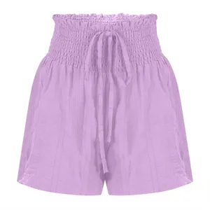 Macro view of purple high-waisted shorts with smocked elastic waist and drawstring.