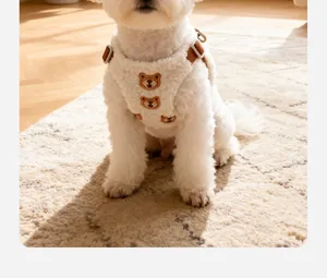Detailed view of a white lamb wool dog harness with cute bear embroidery on a small pet