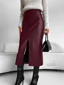 Detailaufnahme eines schmal geschnittenen Kunstleder-Midirocks mit modischem Schlitz.